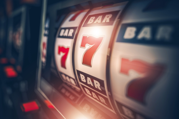 Picture of a gambling slot machine.Picture of a gambling slot machine. The slot machine is showing 3 reels that are all displaying the number 7. Above and below the number 7 you can see the word 'Bar'